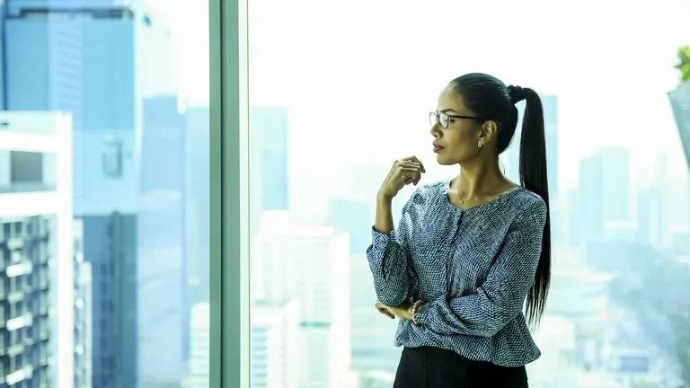 Professional woman pausing at an office window — anxiety and depression therapy in Northern Virginia